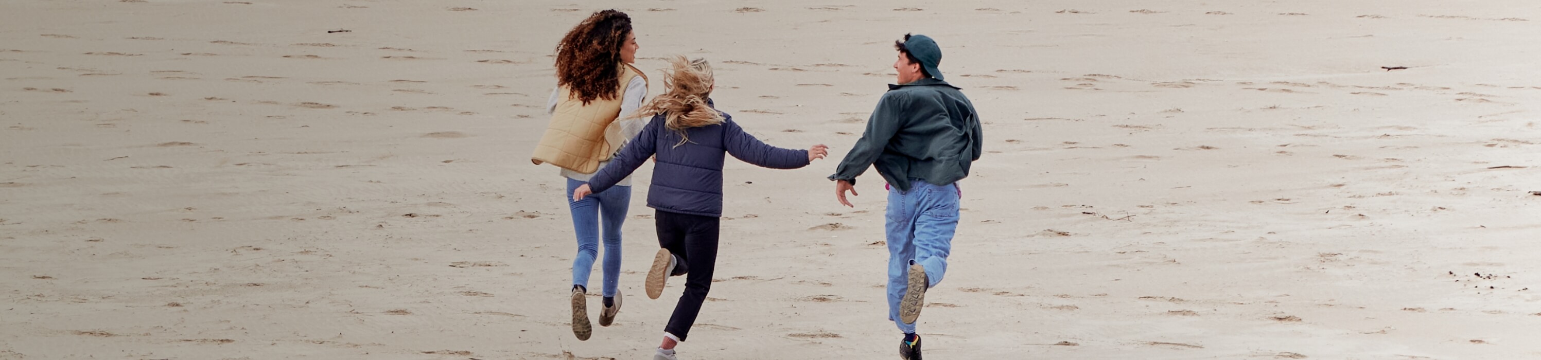 Shop our end of season sale with prices up to 65% off. Image features 3 people running on the beach. 