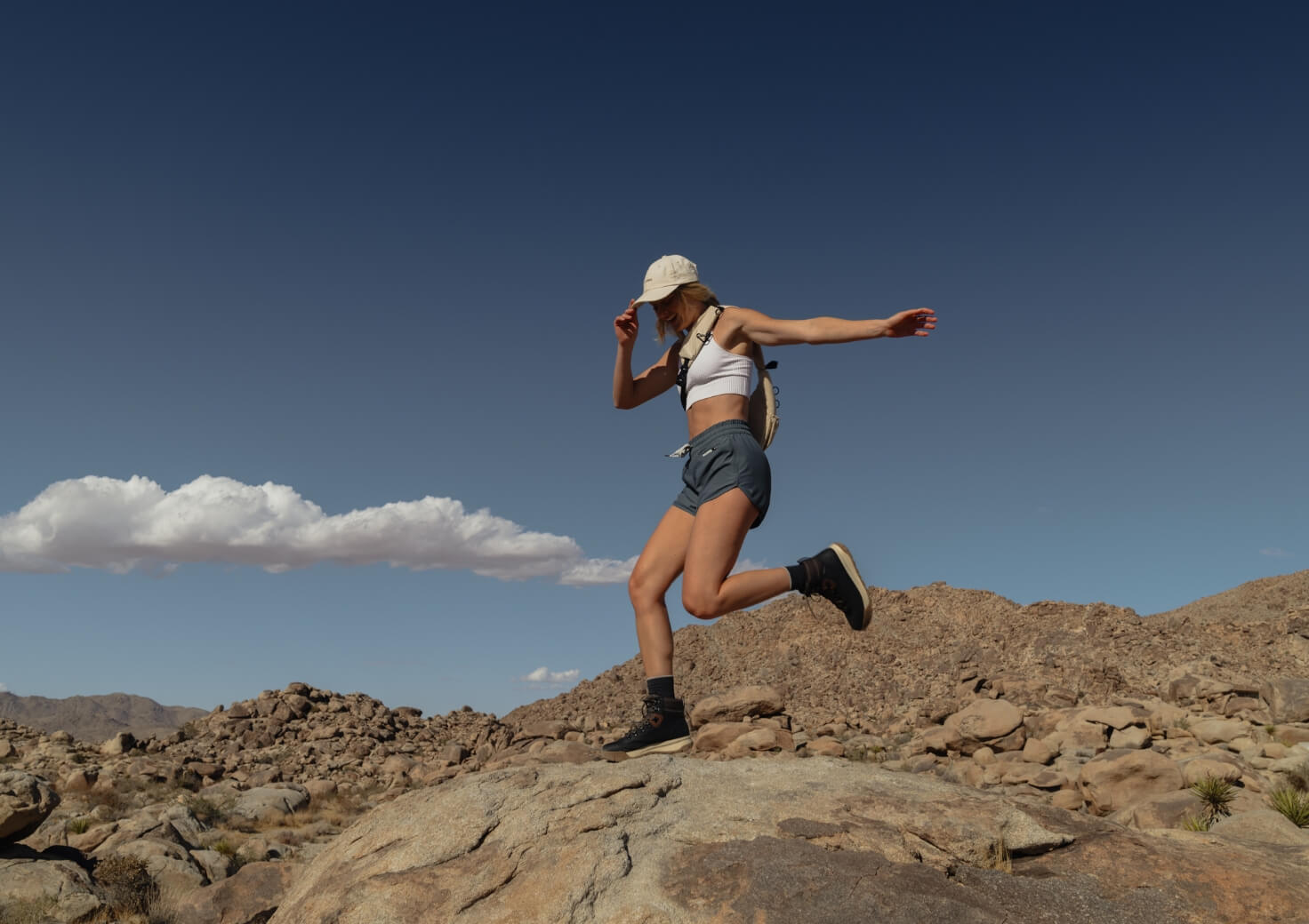 Shop Forsake women's featuring the Patch Mid II in black/tan on top of a rock.