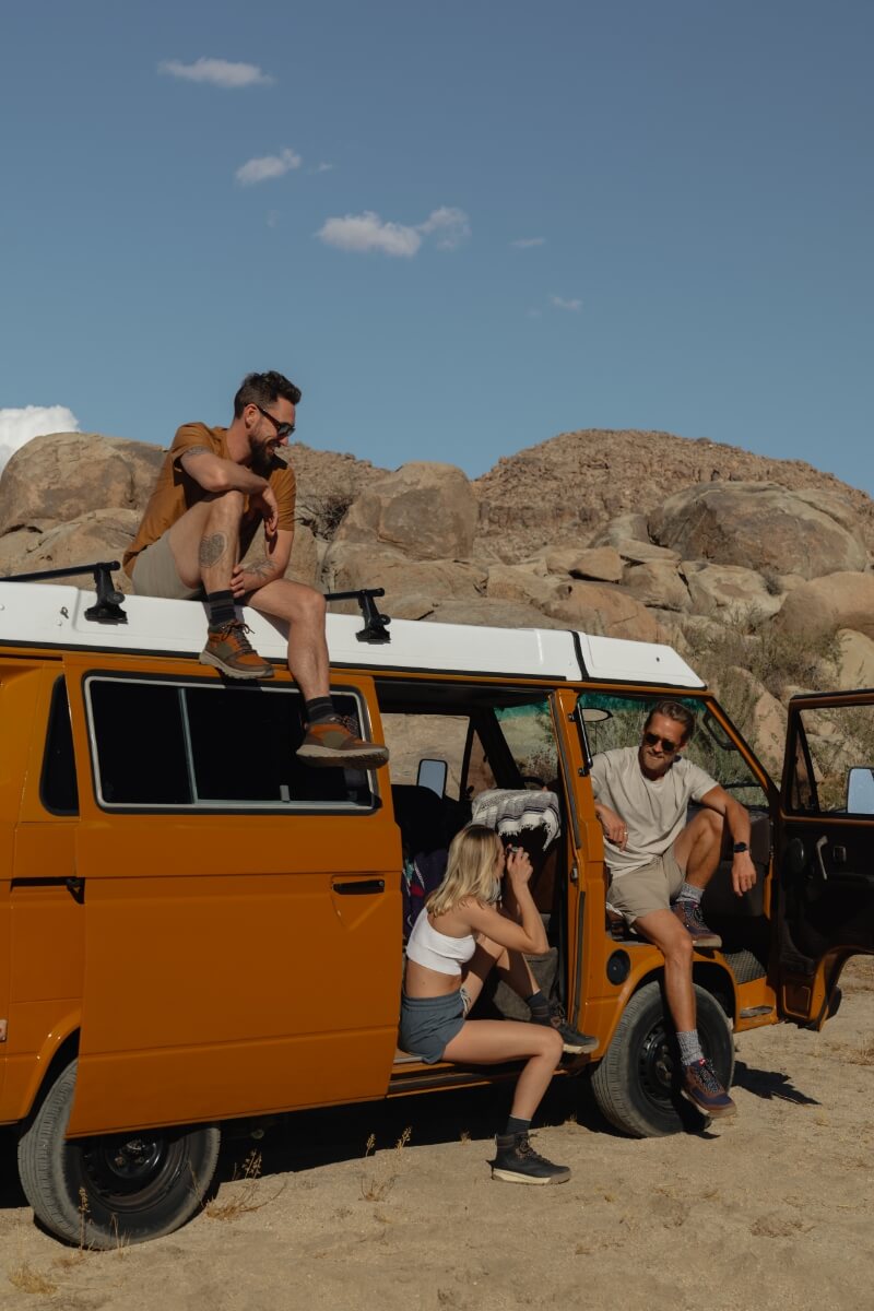 The featured image shows three people sitting in/on an orange van in a desert surrounded by rocks and wearing Forsake shoes.