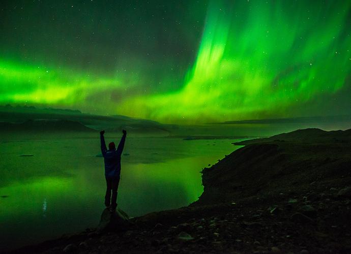 The image features astrophotographer Jack Fusco posing in front of the Northern Lights. 