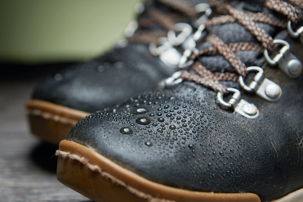 The image features the toe of Forsake Boots with water droplets. 